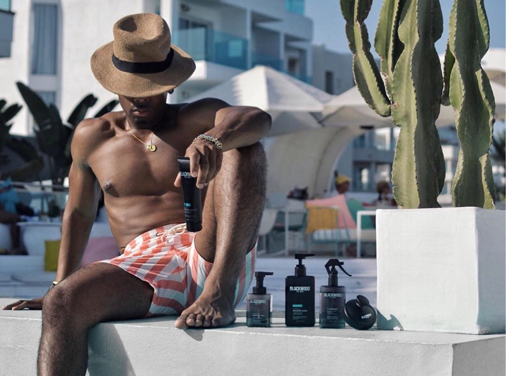 Man sitting next to the pool with Blackwood for Men products